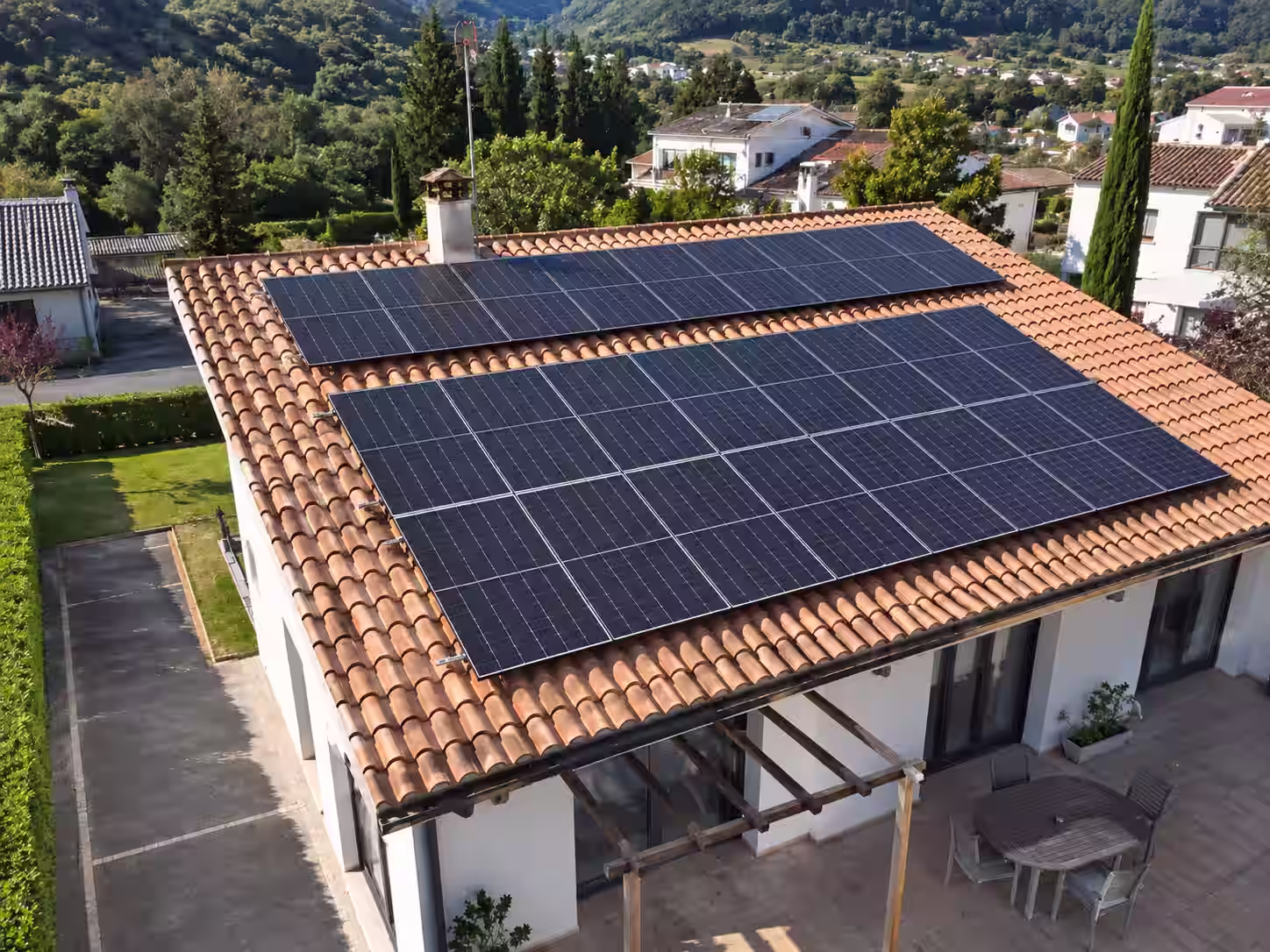 Paneles fotovoltaicos instalados sobre el tejado de tejas de una vivienda.